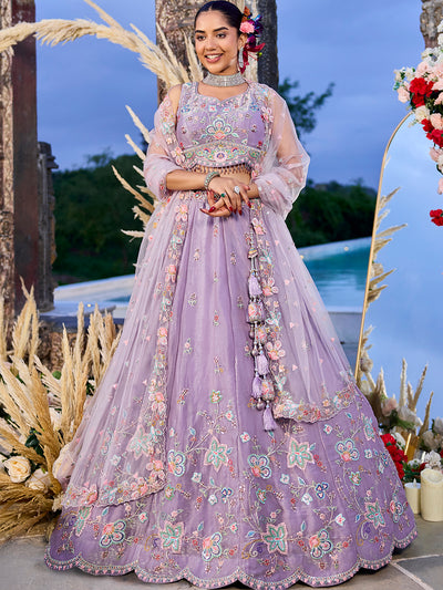 Woman in a lavender embroidered traditional outfit with floral decorations in an outdoor setting.